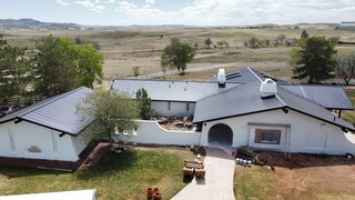 Residential metal roof installation by New Roof Plus. This ranch style home installed standing seam metal roofing and made this home go from really cool classic adobe style ranch to a sophisticated modern villa.