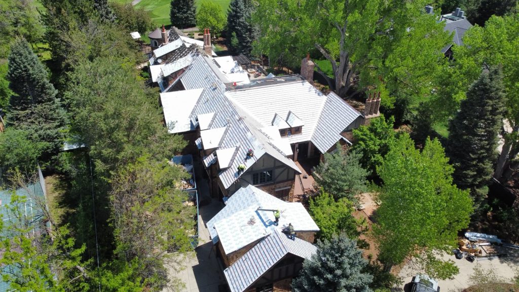 Large residential home near Denver Colorado in Cherry Hills Village, gets a new roof with stone-coated steel and flat roof replacement.