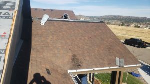 Castle Rock roof installation after hail storm. Damaged roofing shown in this image was removed and new shingles installed by New Roof Plus. This home, located at 4027 Broken Hill Dr, Castle Rock, CO 80109 filed an Insurance claim and New Roof Plus helped in the process. This is an image from the case study on the process of making an insurance claim for roof replacement after storm damage.